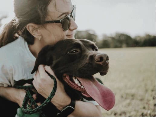 woman hugging her large brown labrador