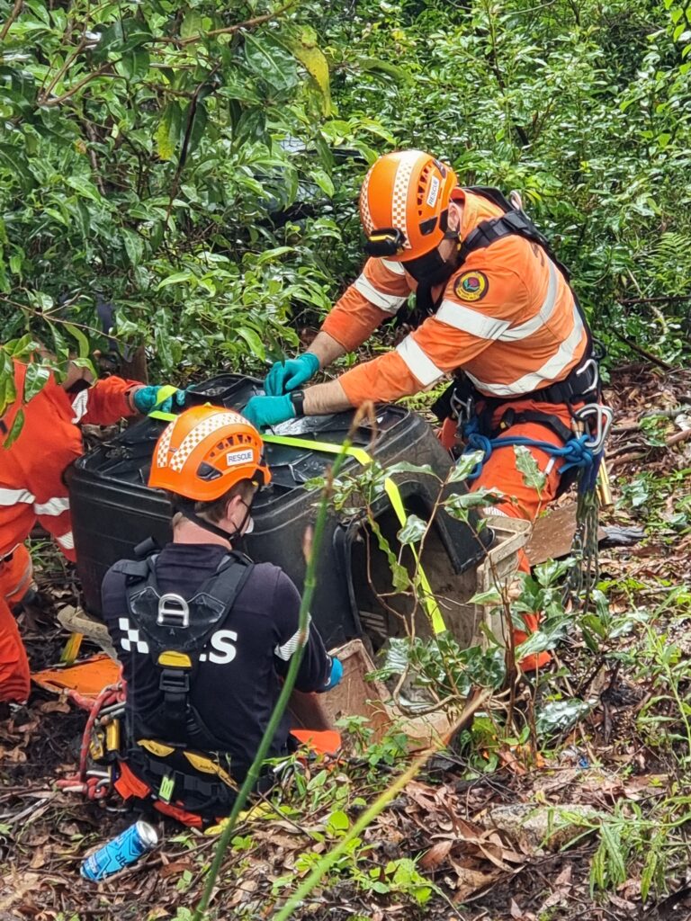 NSW Police and SES officers retrieve a kennel, containing an injured dog, from the base off a cliff before woman charged with animal cruelty in NSW.
