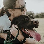 woman cuddling her big brown dog
