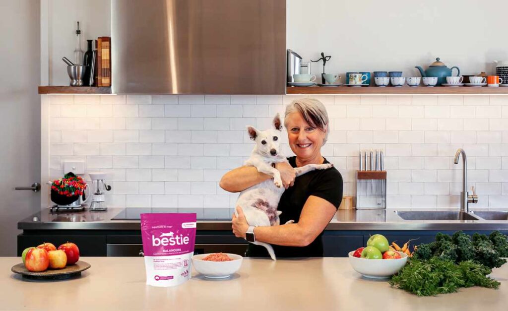 Photo of The Pet Nutrition Show podcast host Amanda Falconer in the kitchen with her dog Alfie. The show aims to highlight sustainable pet food 