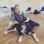 Pea Horsley sitting on a wooden floor beside a black-and-white dog