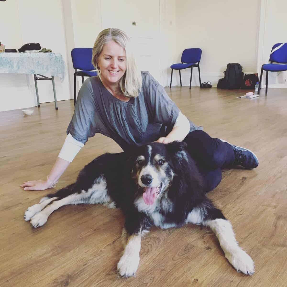 Pea Horsley sitting on a wooden floor beside a black-and-white dog