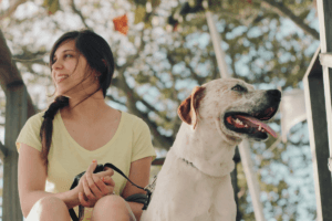 A woman sits with her dog for article navigating pet custody during separation under new family law reforms