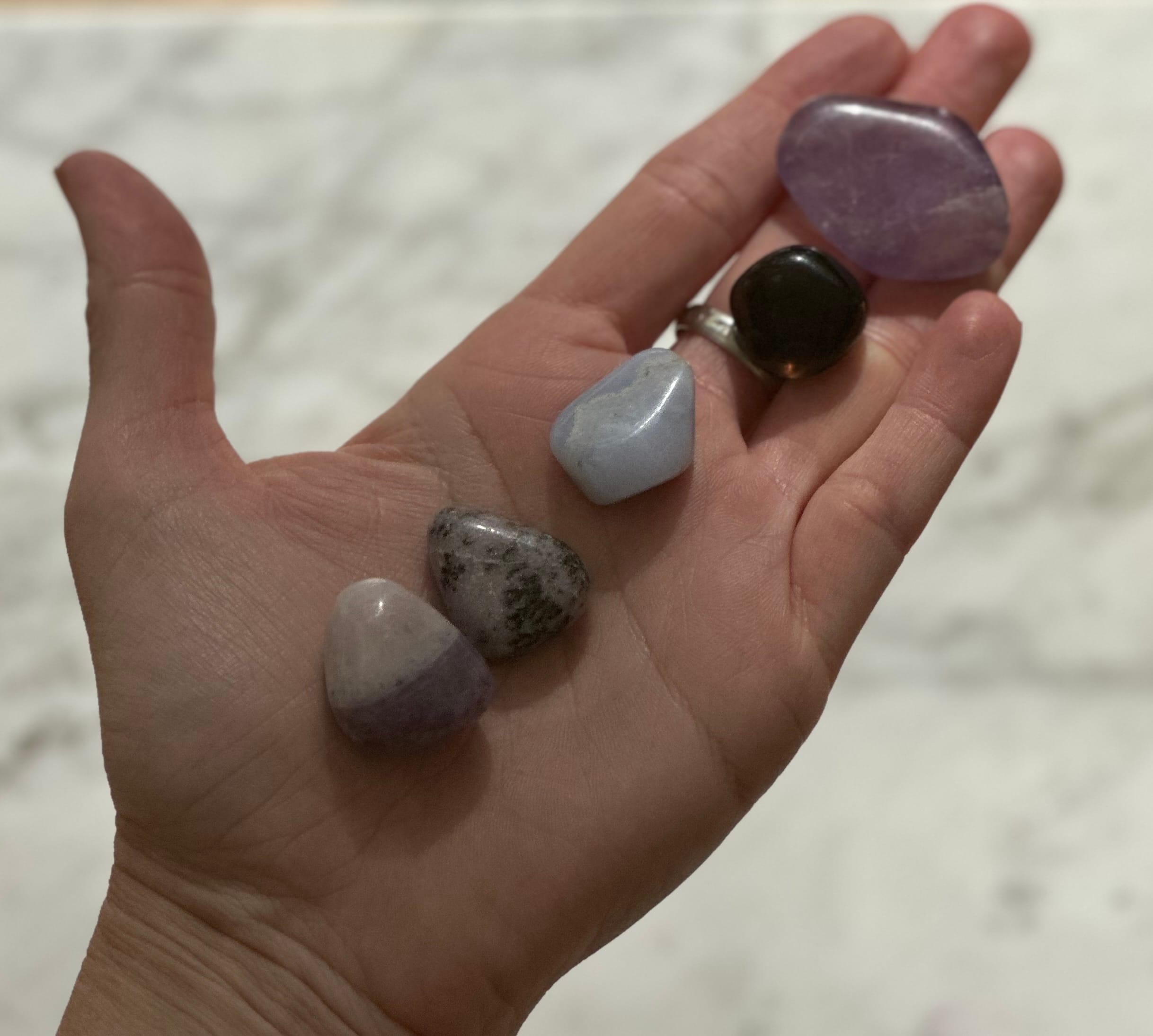 Hand displaying five healing crystals for pets for Animal Friendly Life