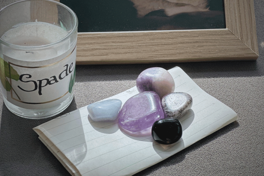 Aesthetic flat lay image of crystals on a folded up manifestation paper in front of candle for animal healing spiritual rituals
